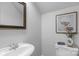 Powder room features a pedestal sink, artwork, and classic fixtures at 9227 Island Overlook Ct, Cornelius, NC 28031