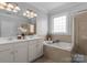 Luxurious bathroom with double vanity, bathtub, and separate shower stall at 9227 Island Overlook Ct, Cornelius, NC 28031