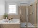 Bright bathroom featuring soaking tub with tray, glass shower, and modern tile work at 9227 Island Overlook Ct, Cornelius, NC 28031