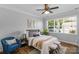 Cozy bedroom featuring large window, stylish furnishings, and a ceiling fan at 9227 Island Overlook Ct, Cornelius, NC 28031