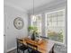 Bright dining area with stylish wood table, a clock, and natural light from large windows at 9227 Island Overlook Ct, Cornelius, NC 28031