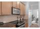 Kitchen features stainless steel microwave and oven, hardwood cabinets and tile backsplash at 9227 Island Overlook Ct, Cornelius, NC 28031