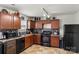 Well-equipped kitchen boasts dark cabinets, black appliances, and sleek subway tile backsplash at 9612 Old Dowd Rd, Charlotte, NC 28214