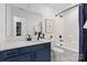 Modern bathroom with a blue vanity, a shower-tub combo, and black and white patterned floor tiles at 102 Cartington Way # Haf0042, Mooresville, NC 28115