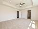 Spacious bedroom with neutral carpet, a tray ceiling, and multiple doors leading to other areas of the house at 102 Cartington Way # Haf0042, Mooresville, NC 28115