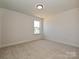 A minimalist bedroom with neutral tones, a single window, and soft carpeting provides a blank canvas for new owners at 102 Cartington Way # Haf0042, Mooresville, NC 28115