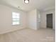 An airy bedroom with neutral walls and carpet features a window and a closet, ready for personalization at 102 Cartington Way # Haf0042, Mooresville, NC 28115