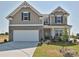 Beautiful two-story home with a white garage door, charming brick accents, and a well-manicured lawn at 102 Cartington Way # Haf0042, Mooresville, NC 28115