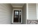 Elegant front door with glass accents and a sidelight, complemented by a brick base and gray siding at 102 Cartington Way # Haf0042, Mooresville, NC 28115