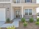 Inviting front porch with a glass door, stylish brick accents, and manicured landscaping, creating curb appeal at 102 Cartington Way # Haf0042, Mooresville, NC 28115