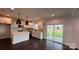 Open-concept kitchen with stainless appliances, white cabinetry, central island, and sliding door access to the patio at 102 Cartington Way # Haf0042, Mooresville, NC 28115