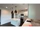 Contemporary kitchen boasts a center island, stainless steel appliances, sleek white cabinets, and pendant lighting at 102 Cartington Way # Haf0042, Mooresville, NC 28115