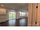 Open living area with dark hardwood floors and access to the kitchen and a sliding glass door to the backyard at 102 Cartington Way # Haf0042, Mooresville, NC 28115