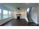 Bright living room with fireplace, ceiling fan, dark wood floors, and staircase to the upper level at 102 Cartington Way # Haf0042, Mooresville, NC 28115