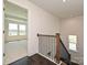 View of the wooden staircase with decorative wrought iron spindles leading to another room filled with light at 102 Cartington Way # Haf0042, Mooresville, NC 28115