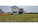 A view of the back exterior with a well-maintained lawn and a covered porch area at 113 Tonbridge Way # Haf0031, Mooresville, NC 28115