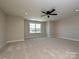 Spacious bedroom with plush carpet, ceiling fan, and a window overlooking the yard at 113 Tonbridge Way # Haf0031, Mooresville, NC 28115