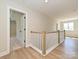 Hallway with wood floors and white railings leading to an open bedroom at 113 Tonbridge Way # Haf0031, Mooresville, NC 28115