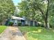 View of the home's exterior with a lovely front yard featuring a mature tree and lush landscaping at 11421 Kingfisher Dr, Charlotte, NC 28226