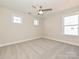 Bright bedroom with soft carpet, ceiling fan, and multiple windows offering abundant natural light at 119 Tonbridge Way # Haf0033, Mooresville, NC 28115