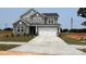 Two-story home featuring a gray color scheme, stone accents, a two-car garage, and a well-manicured front lawn at 119 Tonbridge Way # Haf0033, Mooresville, NC 28115