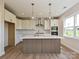 Contemporary kitchen with white cabinets, stainless steel appliances, an island, and plenty of natural light at 119 Tonbridge Way # Haf0033, Mooresville, NC 28115