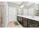 Bathroom with double sink vanity, large mirror, neutral paint, and tiled floors, offering functionality and style at 12014 Belmont Mansion Dr, Charlotte, NC 28273