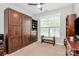 Bedroom with a dark wood Murphy bed, shelving and bench near a bright window at 12014 Belmont Mansion Dr, Charlotte, NC 28273