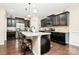 Modern kitchen boasts dark cabinets, granite countertops, stainless steel appliances, and a large center island with seating at 12014 Belmont Mansion Dr, Charlotte, NC 28273