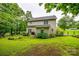 Backyard view showing home's exterior, lawn, and garden area with mature trees at 1206 Craig Ave, Lancaster, SC 29720