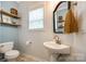Bright bathroom featuring a pedestal sink, toilet, and a window for natural light at 1206 Craig Ave, Lancaster, SC 29720