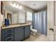 Well-lit bathroom featuring a blue vanity, granite countertop, and a shower-tub combination, offering functionality at 1206 Craig Ave, Lancaster, SC 29720