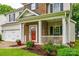 Inviting covered front porch with white railing, brick accents, and vibrant flower beds creating a welcoming entrance at 1206 Craig Ave, Lancaster, SC 29720