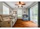 Comfortable living room with hardwood floors, ceiling fan, and sliding glass door to backyard at 1206 Craig Ave, Lancaster, SC 29720