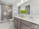 Modern bathroom with a dual sink vanity, a large framed mirror, and a tiled shower with glass doors at 1216 Links Crossing Dr # 159, Monroe, NC 28112