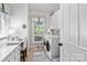Efficient laundry room with white cabinets, modern machines, and convenient desk space at 1520 Cureton Dr, Rock Hill, SC 29732
