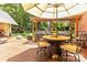 Inviting outdoor dining area on a wooden deck, featuring a round table, chairs, and umbrella with views of the landscaped backyard at 1520 Cureton Dr, Rock Hill, SC 29732