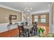 Formal dining room features a glass-top table, chandelier, and hardwood flooring at 15203 Oldcorn Ln, Charlotte, NC 28262