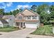 Charming two-story home featuring a stone facade, a covered front porch, and an attached two-car garage at 15203 Oldcorn Ln, Charlotte, NC 28262