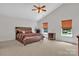 Bright main bedroom features a ceiling fan, carpet flooring, and natural light through the windows at 15203 Oldcorn Ln, Charlotte, NC 28262