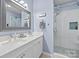 Well-lit bathroom featuring double sinks and a glass shower door at 15432 Coventry Court Ln, Charlotte, NC 28277