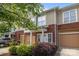 Charming townhome featuring a red brick facade, tan siding, a one-car garage, and well-maintained landscaping at 15432 Coventry Court Ln, Charlotte, NC 28277