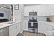 Updated kitchen featuring white cabinets, stainless steel appliances, and a tile backsplash at 15432 Coventry Court Ln, Charlotte, NC 28277