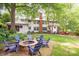 Spacious backyard featuring a fire pit with Adirondack chairs and mature trees offering shade and privacy at 1801 E 8Th St, Charlotte, NC 28204