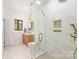 Bright bathroom with glass shower, white tile, wood vanity, and modern fixtures at 1801 E 8Th St, Charlotte, NC 28204