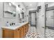 Bathroom with a double vanity, patterned tile floors, and a glass-enclosed shower at 1801 E 8Th St, Charlotte, NC 28204