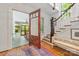 Inviting entryway with hardwood floors, open doorway to porch, stairway, and bench at 1801 E 8Th St, Charlotte, NC 28204