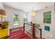 Bright upstairs hallway with hardwood floors, chandelier, and views of the landscaped outdoors at 1801 E 8Th St, Charlotte, NC 28204