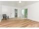 Bright room with hardwood floors, neutral paint, with an accent chair and patio door at 1831 Erie St, Charlotte, NC 28216