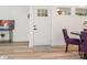 Bright entryway with a white door, decorative rug, and stylish purple dining chairs at 1831 Erie St, Charlotte, NC 28216